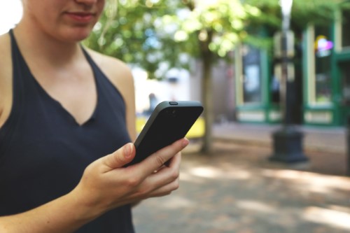 IVR prompts and AA prompts woman holding phone halter top