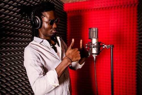 black man dreadlocks thumbs up recording booth microphone